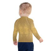 Child wearing CB6-29 Kids Rash Guard at the beach, playing in the sand.